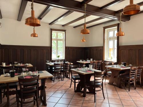 a dining room with tables and chairs and windows at Hotel Brauhaus Bückeburg in Bückeburg