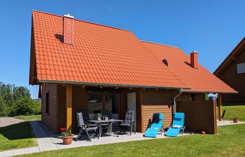 a house with an orange roof with chairs and a table at Premiumferienhaus Anni in Hasselfelde