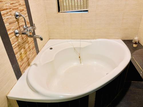 a bath tub in a bathroom with a sink at Island House Goa in Divar