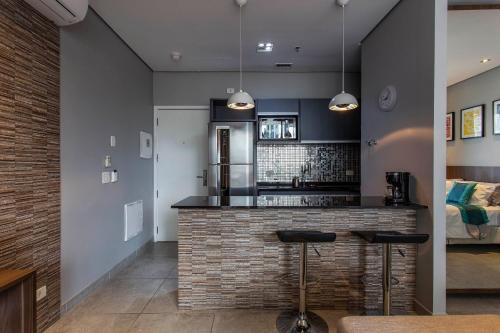 - une cuisine avec un bar avec deux tabourets dans l'établissement FL Residence, à São Paulo