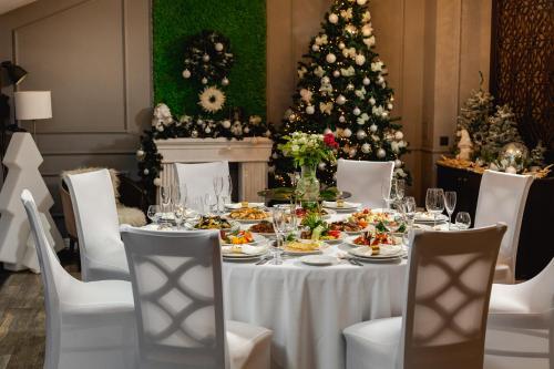 a dining room with a table with food and a christmas tree at Summit Villa in Chişinău
