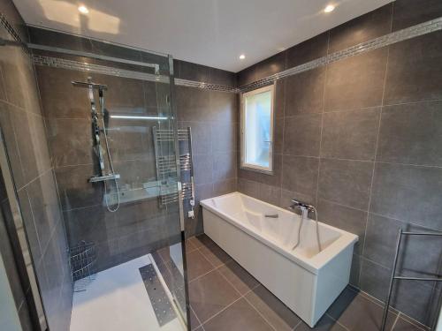 une salle de bain avec une douche, une baignoire et un lavabo dans l'établissement Villa 6 chambres avec piscine chauffée - FR-1-100-252, à Cavalaire-sur-Mer