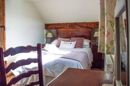 a bedroom with a bed with a wooden headboard at The Snug, Beautiful Country Retreat in Priston