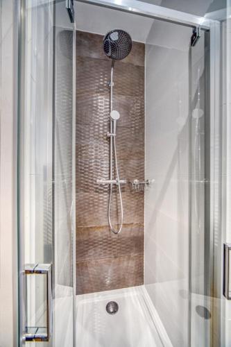 une douche avec une porte vitrée dans une salle de bain dans l'établissement Le Félix 2, studio entièrement équipé et aménagé pour accueillir confortablement 2 personnes, tout proche de la gare de Grenoble sur l'avenue Félix Viallet, à Grenoble