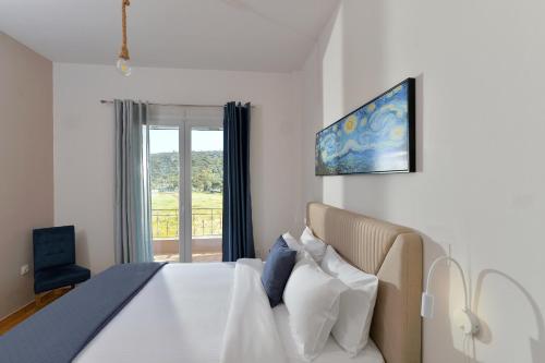 a bedroom with a large bed and a window at Stork Apartments in Vivari
