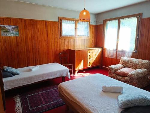 una habitación de hotel con dos camas y una silla en La Maison des Praz, en Saint-Gervais-les-Bains