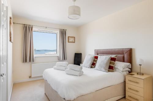 una camera da letto con un grande letto bianco e una finestra di Ahoy a Poole