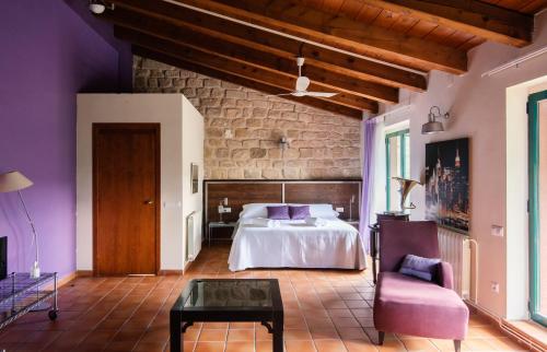 a bedroom with a bed and a couch and a table at Hotel La Parada del Compte in Torre del Compte