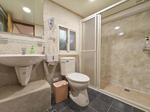 een badkamer met een toilet, een wastafel en een douche bij Qu Hi Home Stay in Jiufen