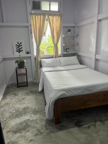 a bedroom with a large bed with a window at KLhomestay in Hāpoli