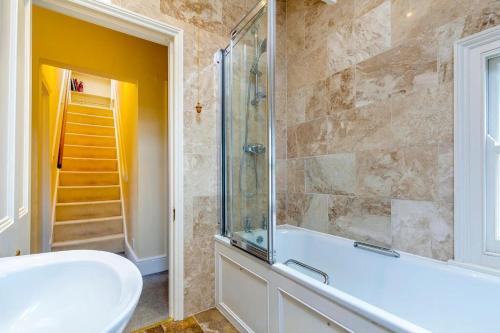 ケンブリッジにあるPass the Keys Spacious Victorian Home with Free Parkingの浴槽、洗面台、シャワーを備えたバスルーム