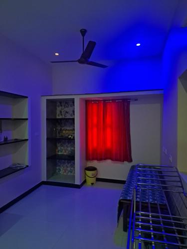 Habitación con ventana roja y cortina roja. en KG Homes, en Chidambaram