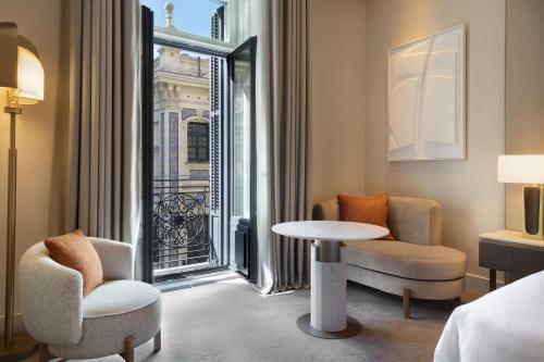 Habitación con 2 sillas, mesa y ventana en JW Marriott Hotel Madrid en Madrid
