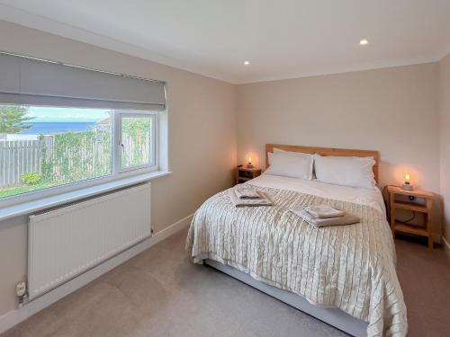 um quarto com uma cama grande e uma janela em Silvershell View em Port Isaac