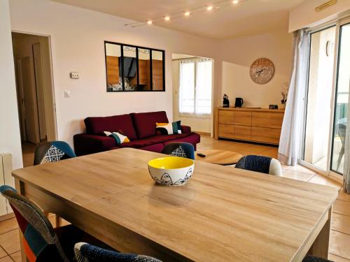 - une salle à manger et un salon avec une table en bois dans l'établissement CAP AUX SABLES avec garage, à Les Sables-dʼOlonne