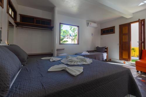 a bedroom with a blue bed with towels on it at Cavalo Marinho Flats in Arraial d'Ajuda