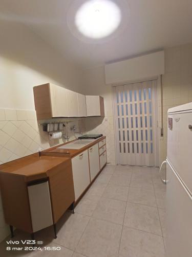Una cocina con electrodomésticos blancos y un refrigerador blanco. en Luisetta, en Massafra