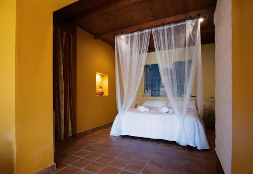 a bedroom with a bed with a canopy at Hospedium Hotel La Parada del Compte in Torre del Compte