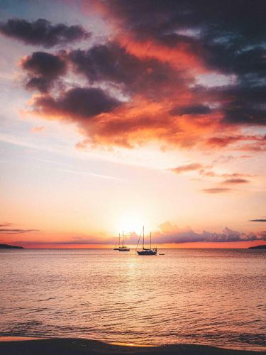two boats on the water at sunset at Le Suffren Hôtel in Grimaud