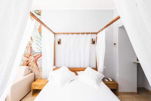 a bedroom with two beds with white walls at Le Suffren Hôtel in Grimaud