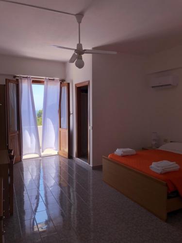 a bedroom with a bed and a ceiling fan at Hotel Ariston in Ustica