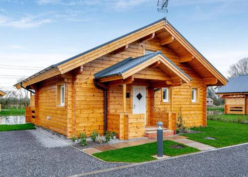 a small log cabin with a white door at Holly Tree Lodges in York