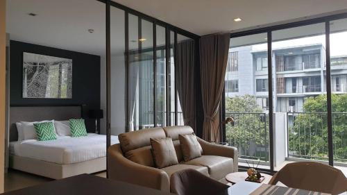 a living room with a couch and a bed and window at Apartment 55 sqm 1bed 3rd floor with poolview and mountainview in Ban Huai Sok Noi