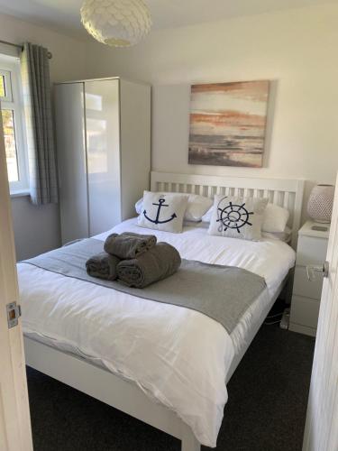 una camera da letto con un grande letto bianco con asciugamani di 44 Gower holiday village Ty Gŵyr Cosy 2 bedroom Chalet a Swansea