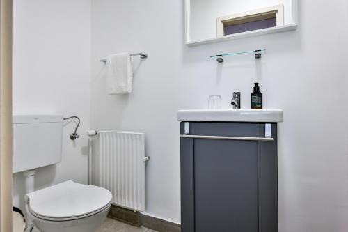a bathroom with a toilet and a sink at Hotel Villa Klasen in Wenningstedt