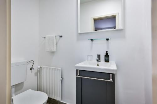 Baño blanco con lavabo y aseo en Hotel Villa Klasen en Wenningstedt