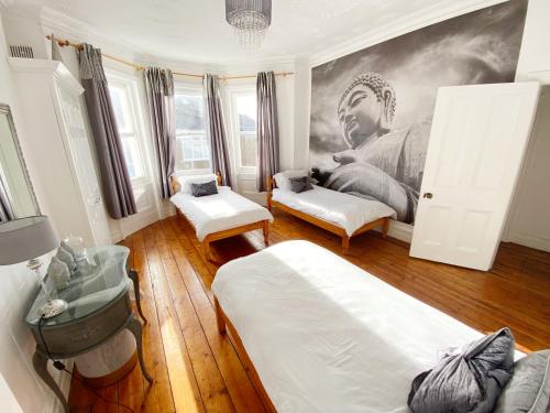 een kamer met 2 bedden en een schilderij aan de muur bij The Table House Close to Town & Beach Free parking in Bournemouth