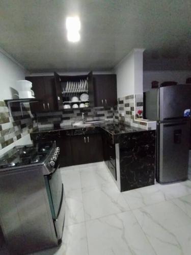 a kitchen with black cabinets and a black refrigerator at RentalsOP Q01 Linda casa en el corazón de Armenia a min de los parques in Armenia
