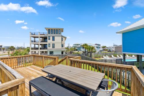 una terraza de madera con mesa de picnic y sillas. en Island Beach Bungalow, en Pensacola Beach