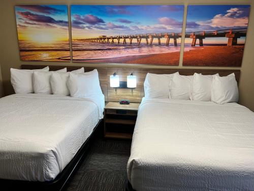 a hotel room with two beds and a pier at Days Inn by Wyndham Monroe NC in Monroe