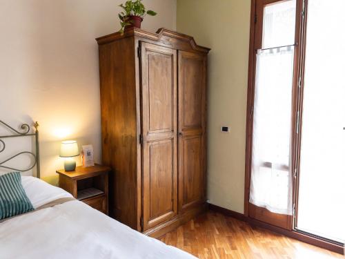 a bedroom with a large wooden cabinet next to a bed at B&B Casa Decimo in Greve in Chianti