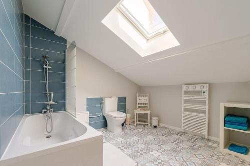 La salle de bains est pourvue d'une baignoire, de toilettes et d'une lucarne. dans l'établissement Le Coin Fertois, à La Ferté-sous-Jouarre