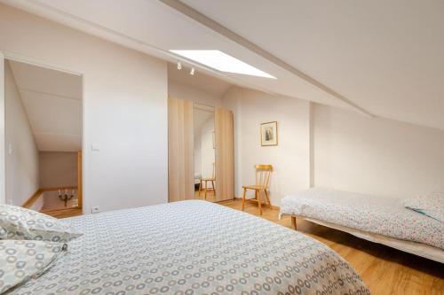 une chambre blanche avec deux lits et une fenêtre dans l'établissement Le Coin Fertois, à La Ferté-sous-Jouarre