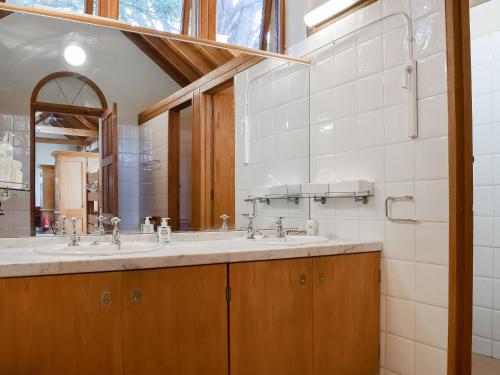 a bathroom with two sinks and a mirror at The Coach House At Waterperry Gardens in Waterperry