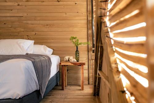 a bedroom with a bed and a table with a plant at Watu Kite House in Mayapo