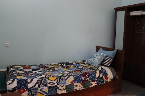a bedroom with a bed with a quilt and pillows at Guest House Ikathouse in Margilan