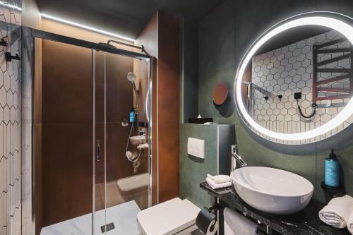 ein Bad mit einer Dusche, einem Waschbecken und einem Spiegel in der Unterkunft Stay inn Hotel Warszawa in Warschau