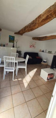 un salon avec une table et des chaises blanches dans l'établissement Cigaloun, à Moissac-Bellevue