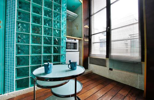 une cuisine avec une table et des murs en blocs de verre dans l'établissement Paris Marais Tiny Boat MERRIB, à Paris