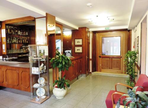 a lobby with a bar and a door with plants at Hotel Signa in Perugia