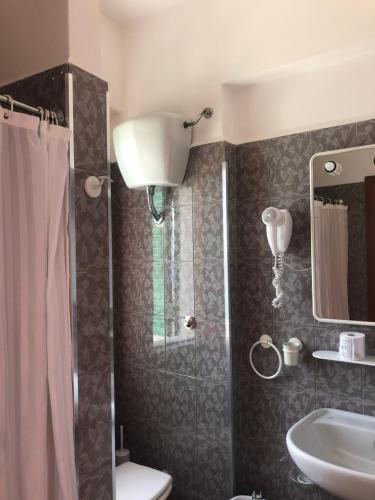 a bathroom with a shower and a toilet and a sink at Hotel Ariston in Ustica