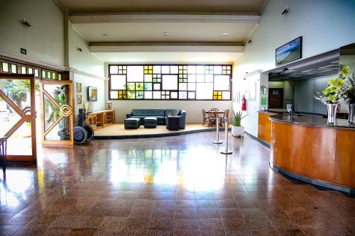 um átrio com uma sala de espera com um sofá e janelas em Verdes Vales Lazer Hotel em Juazeiro do Norte