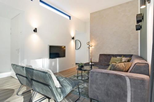 a living room with a couch and a tv at Soof Heuvelrug in Rhenen