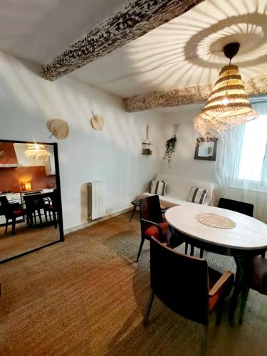 ein Wohnzimmer mit einem Tisch, Stühlen und einem Klavier in der Unterkunft Maison Ellie, Pézenas centre in Pézenas