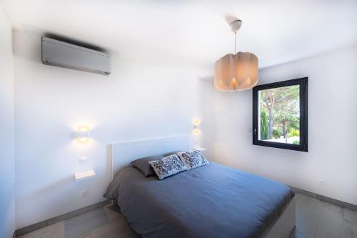 une chambre avec un lit bleu et une fenêtre dans l'établissement Villa Marie-Jeanne, à Sanary-sur-Mer