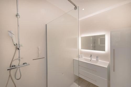 une salle de bain blanche avec une douche et un lavabo dans l'établissement Villa Marie-Jeanne, à Sanary-sur-Mer
